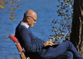 Elderly Man sitting on a bench beside the sea