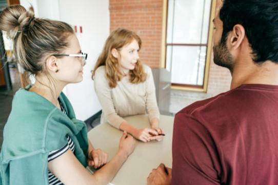 2 women and 1 man talking