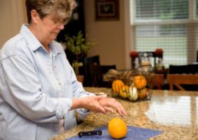 Woman in kitchen with painfull hands